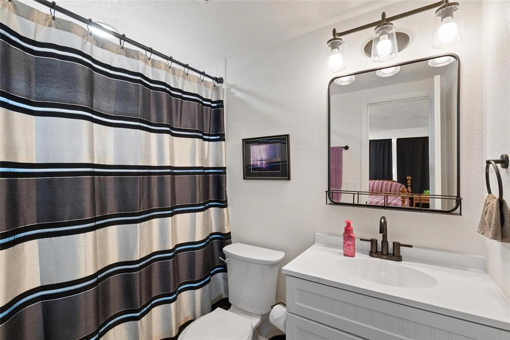 5707 Tennessee Avenue New Port Richey, FL 34652 - Photo 10 of 26 a bathroom with a toilet a sink and mirror