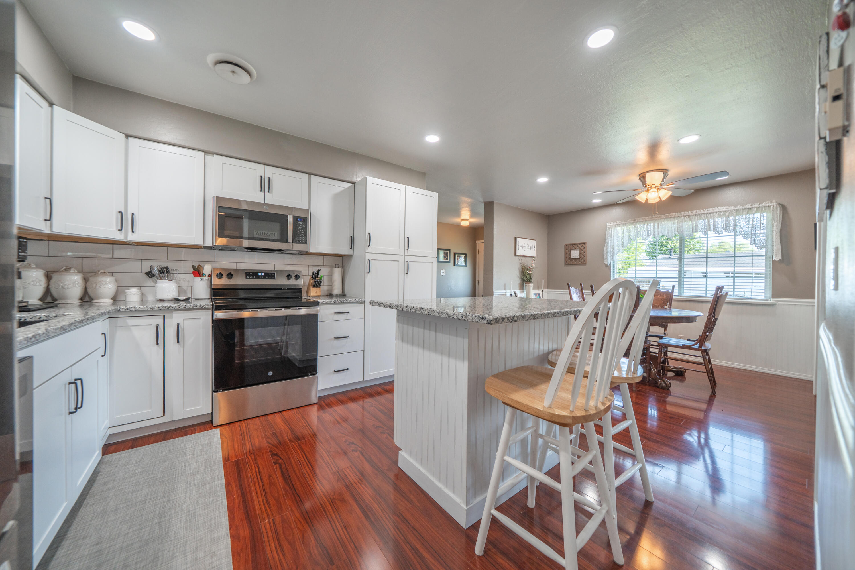 37255 Carson Street Burney, CA 96013 - Photo 16 of 40 a kitchen with stainless steel appliances granite countertop a stove top oven a sink dishwasher a dining table and chairs with wooden floor