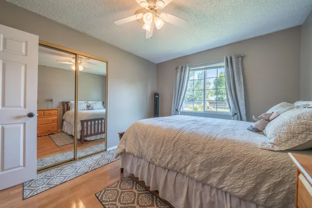 a bedroom with a bed a chandelier and mirror