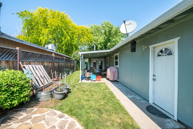 a view of a chair and table in backyard of the house