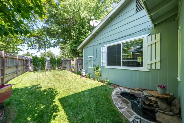 a view of a backyard with table and chairs and wooden fence