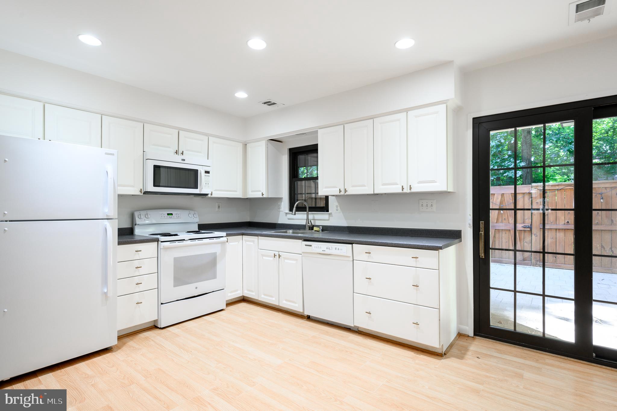 2060 Headlands Circle Reston, VA 20191 - Photo 7 of 26 a kitchen with granite countertop white cabinets and white appliances