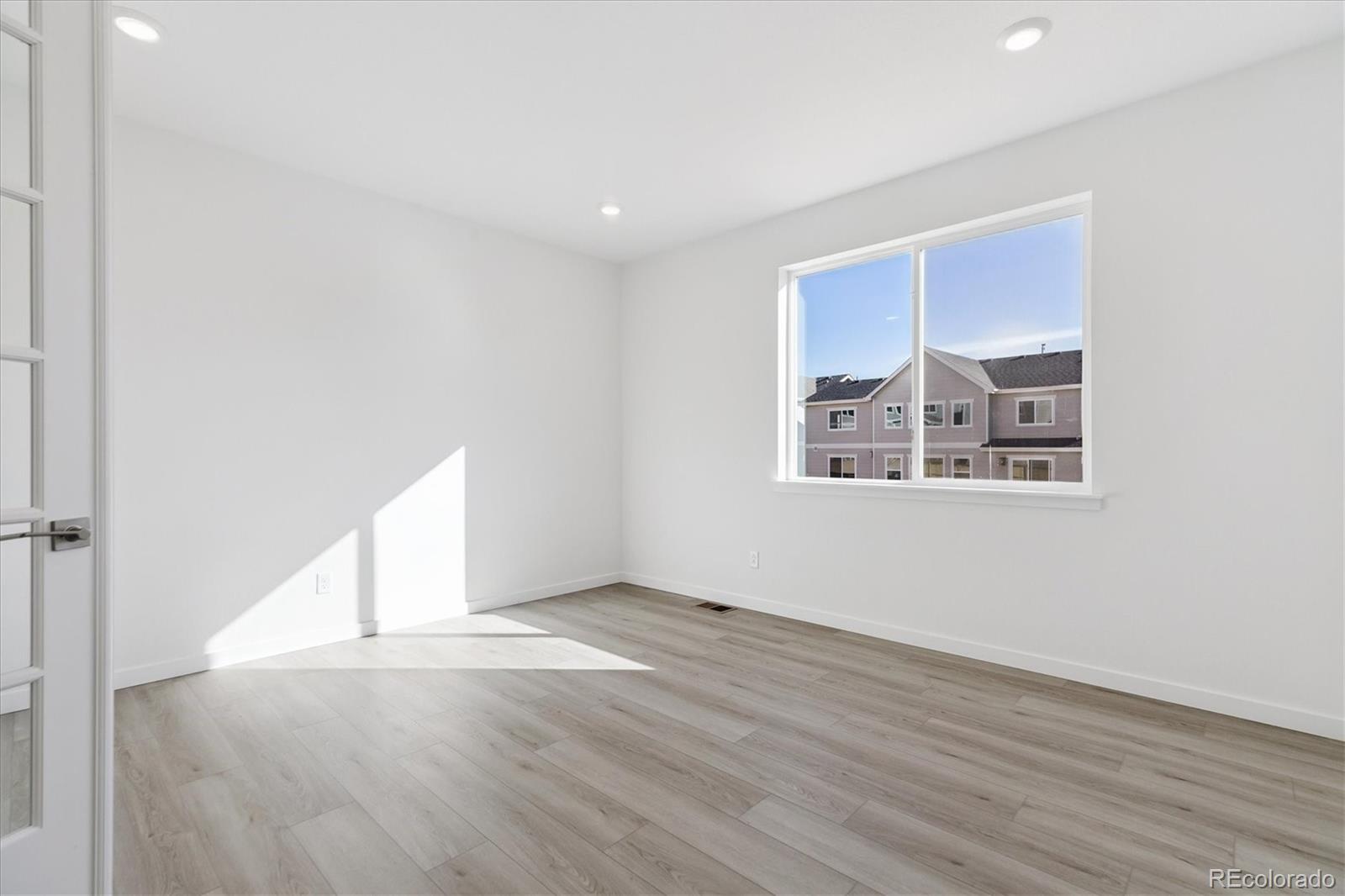2572 West Bitterroot Place Highlands Ranch, CO 80129 - Photo 13 of 30 an empty room with wooden floor and windows