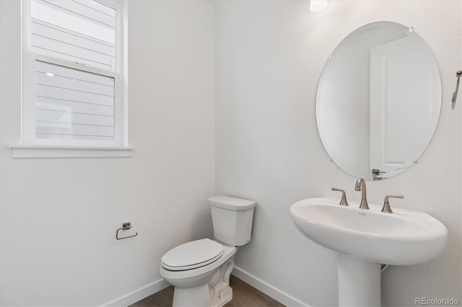 2572 West Bitterroot Place Highlands Ranch, CO 80129 - Photo 14 of 30 a bathroom with a toilet a sink and mirror
