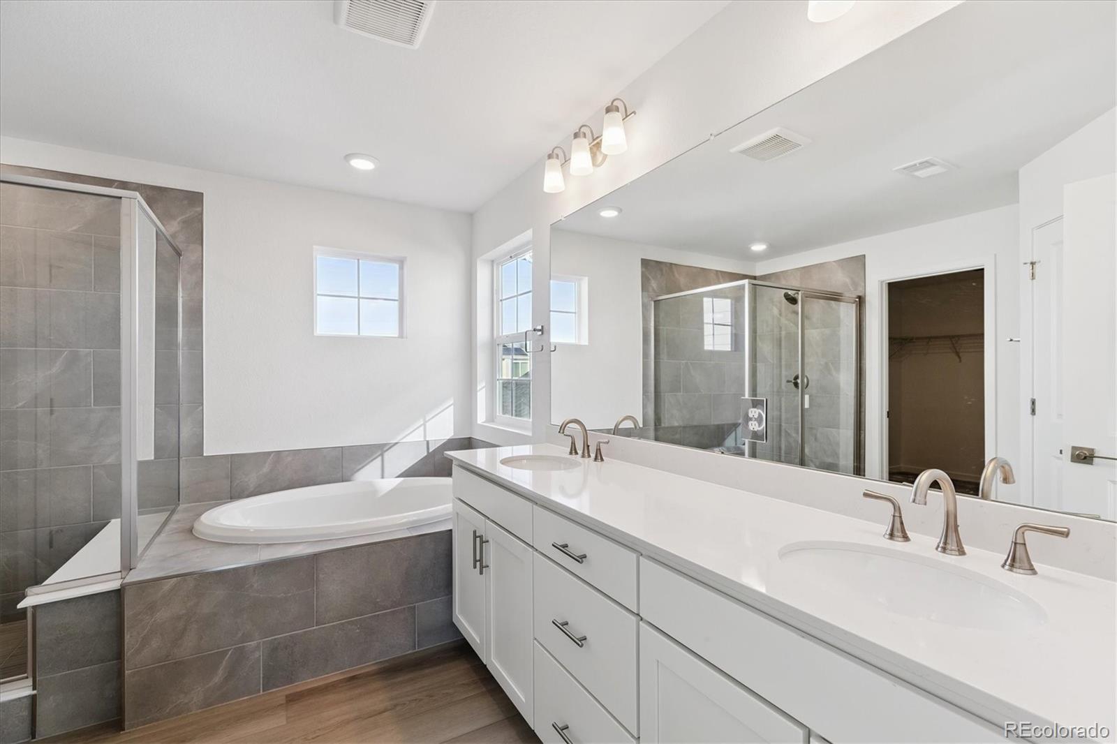 2572 West Bitterroot Place Highlands Ranch, CO 80129 - Photo 17 of 30 a bathroom with a sink double vanity granite tub shower and a mirror