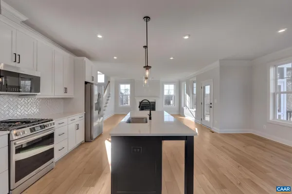 a kitchen with sink stove and refrigerator