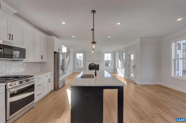 a kitchen with sink stove and refrigerator
