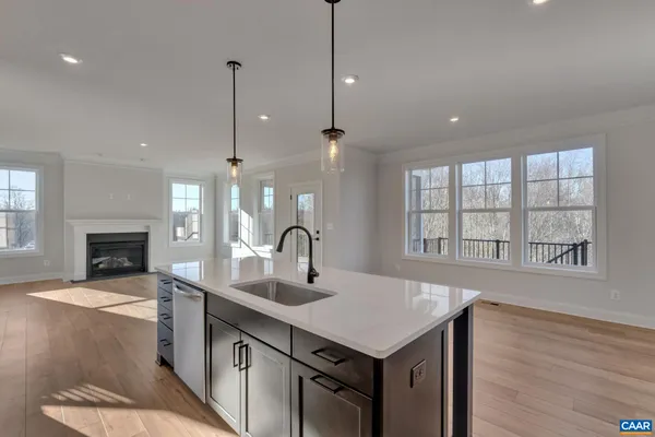 a kitchen with a sink a fireplace and cabinets