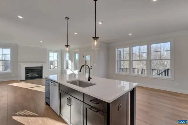 a kitchen with a sink a fireplace and cabinets