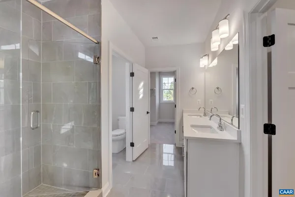 a bathroom with a double vanity sink and shower