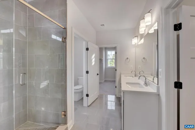 a bathroom with a double vanity sink and shower