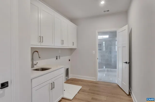 a kitchen with stainless steel appliances granite countertop a sink and cabinets with wooden floor