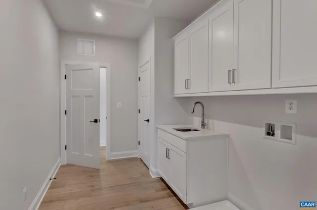 a kitchen with white cabinets and sink