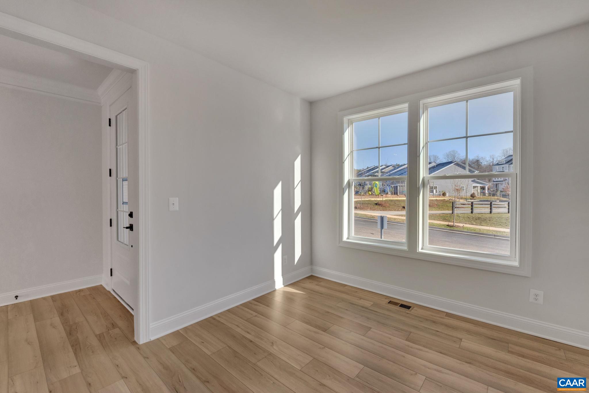 109 B Marcella Street Charlottesville, VA 22911 - Photo 6 of 36 a view of an empty room with a window and wooden floor