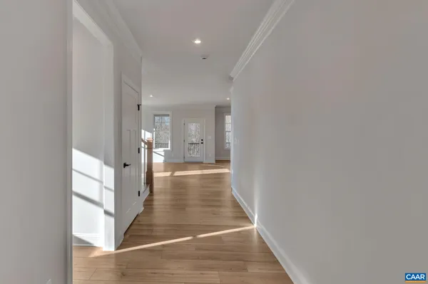 a view of a hallway with wooden floor and staircase