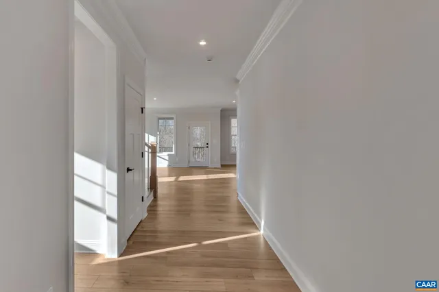 a view of a hallway with wooden floor and staircase