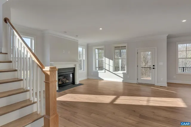 a view of a livingroom with wooden floor and kitchen view