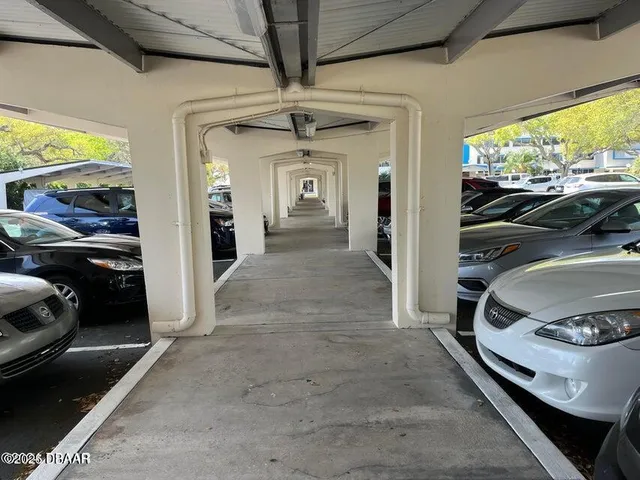 a view of an empty room with a chandelier fan