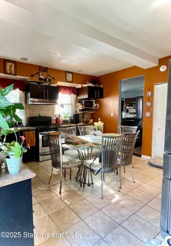 a dining hall with furniture a window and kitchen view