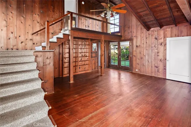 a large kitchen with wooden floor and large windows