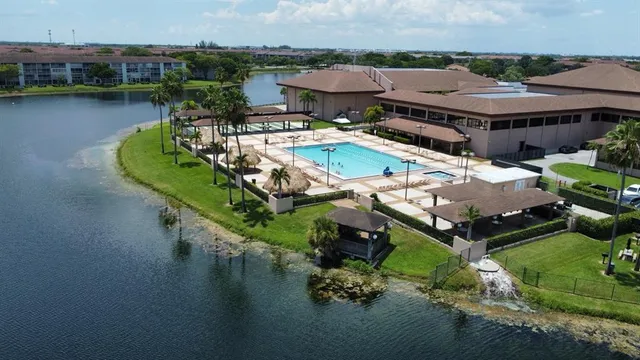 an aerial view of a house with swimming pool and lake view