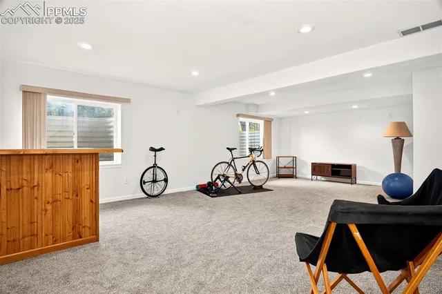 a view of an empty room with wooden floor and windows