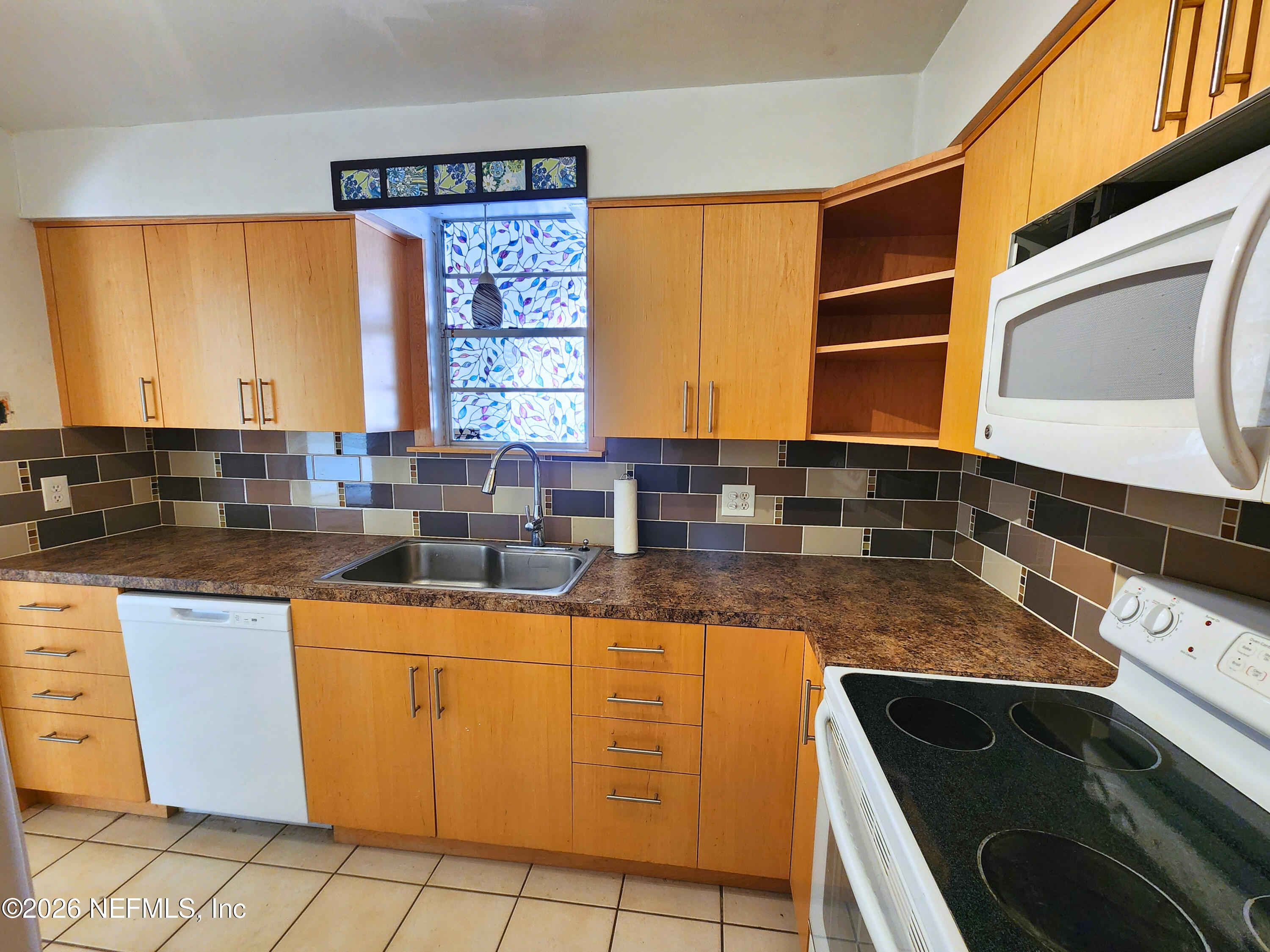 1716 El Camino Road, Unit 1 Jacksonville, FL 32216 - Photo 3 of 15 a kitchen with granite countertop a sink and a stove