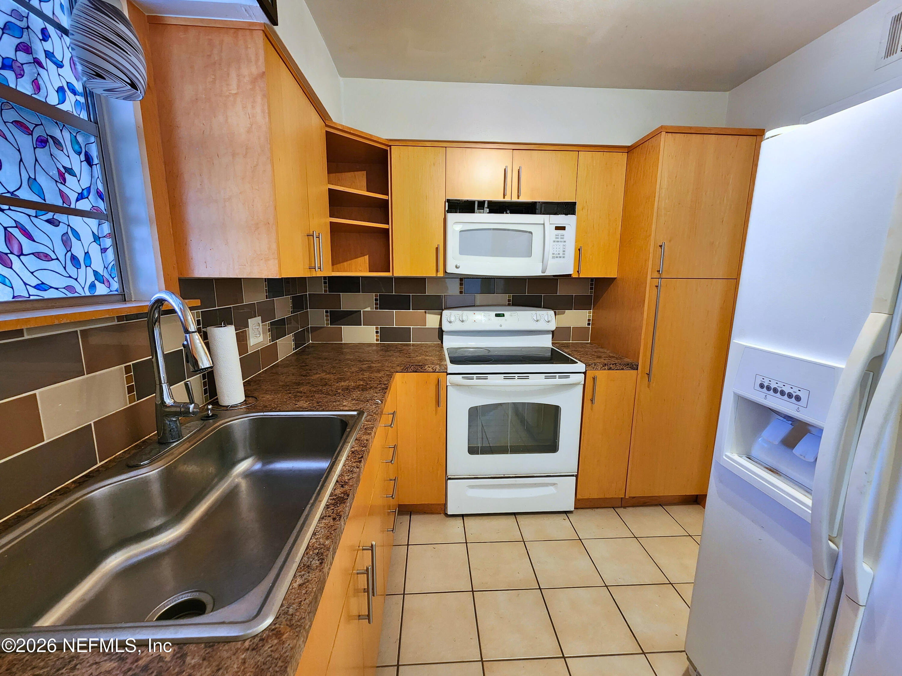 1716 El Camino Road, Unit 1 Jacksonville, FL 32216 - Photo 4 of 15 a kitchen with a sink a stove top oven a refrigerator and a microwave oven