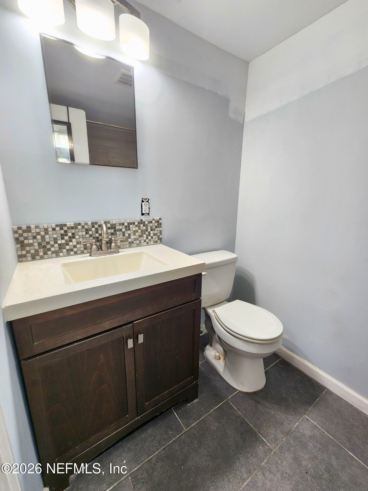 1716 El Camino Road, Unit 1 Jacksonville, FL 32216 - Photo 9 of 15 a bathroom with a toilet a sink and mirror