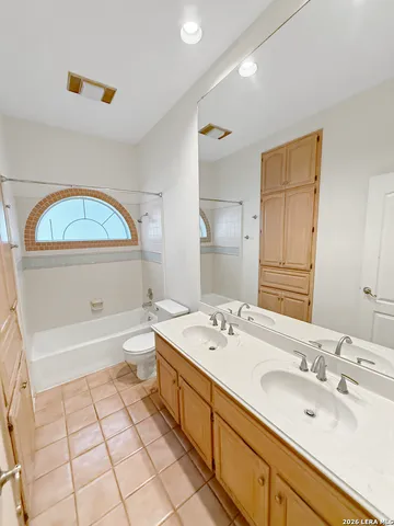 a spacious bathroom with a tub sink and a mirror