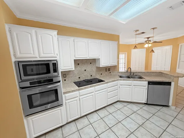 a kitchen with granite countertop white cabinets and white appliances