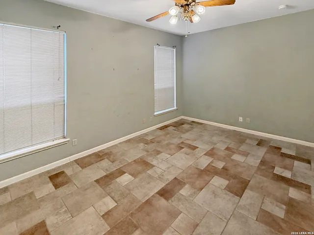 a view of empty room with wooden floor and ceiling fan