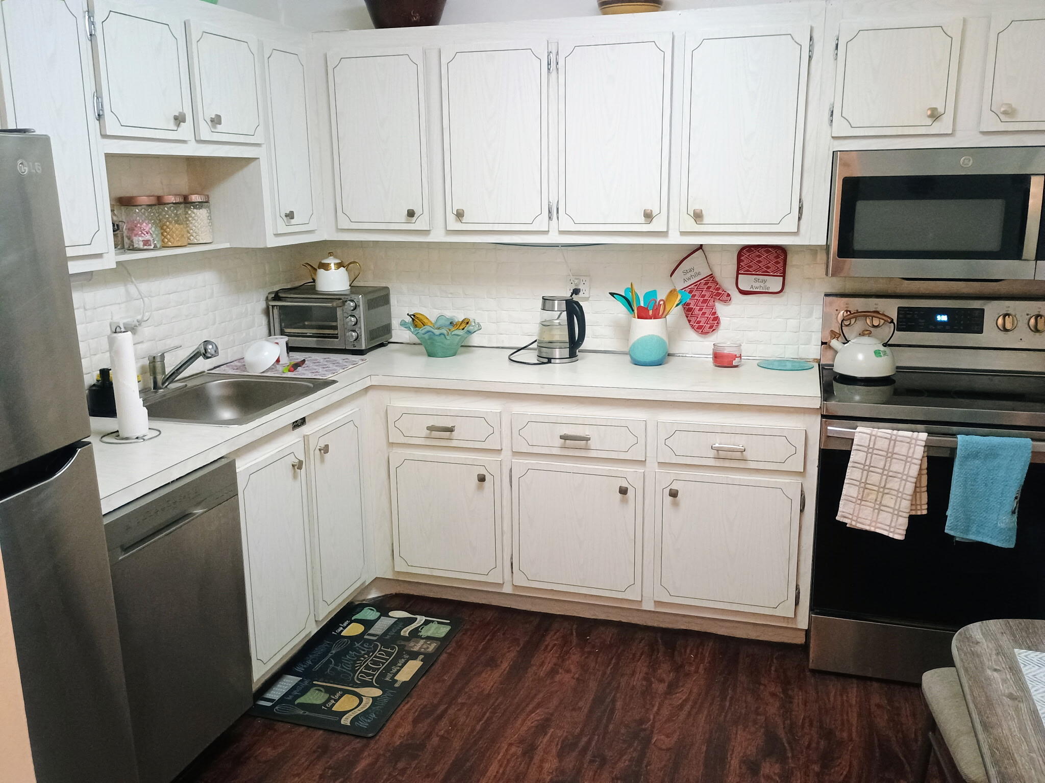 a kitchen with stainless steel appliances granite countertop a stove a sink and white cabinets