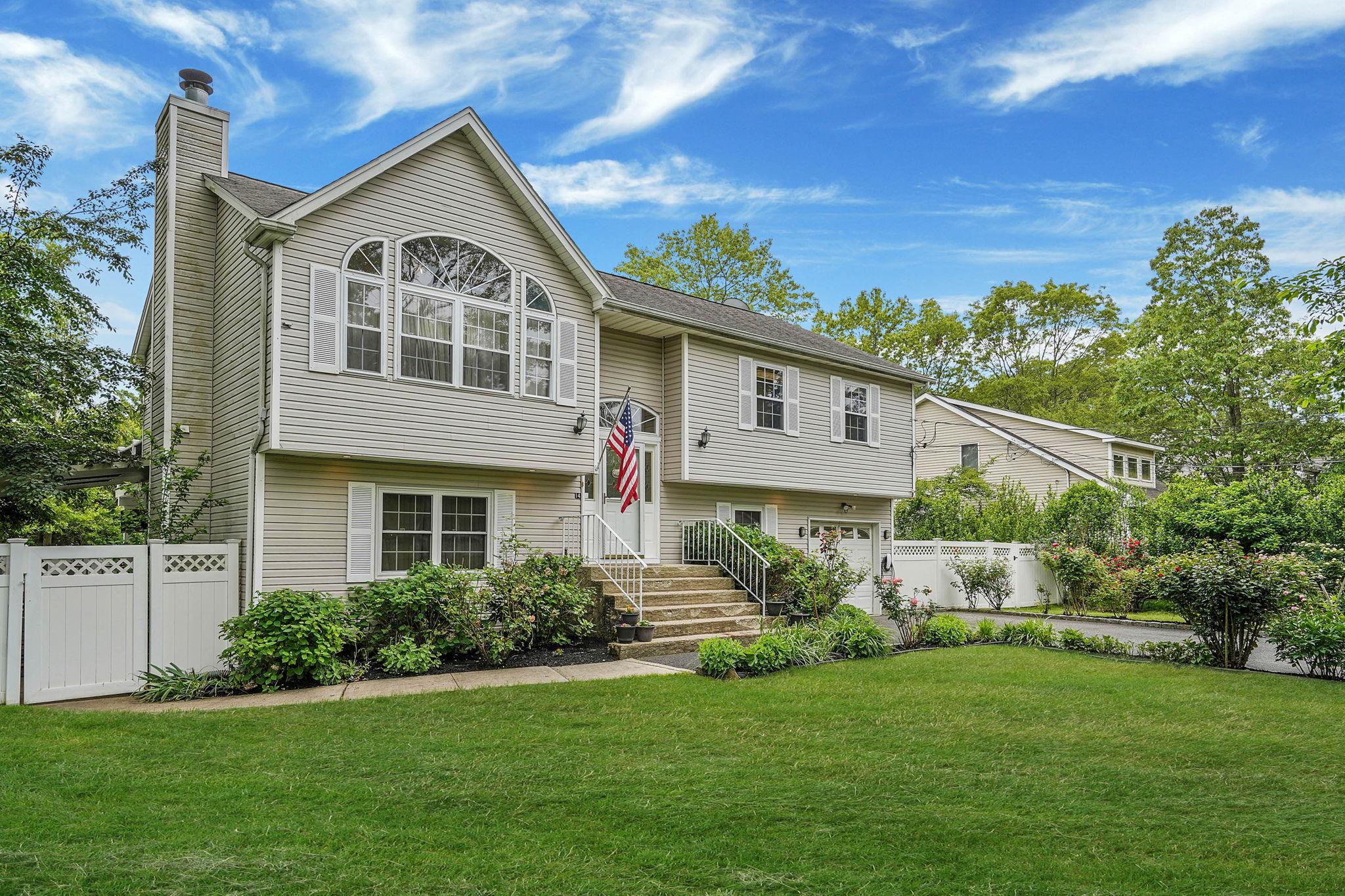 a front view of a house with a garden and plants
