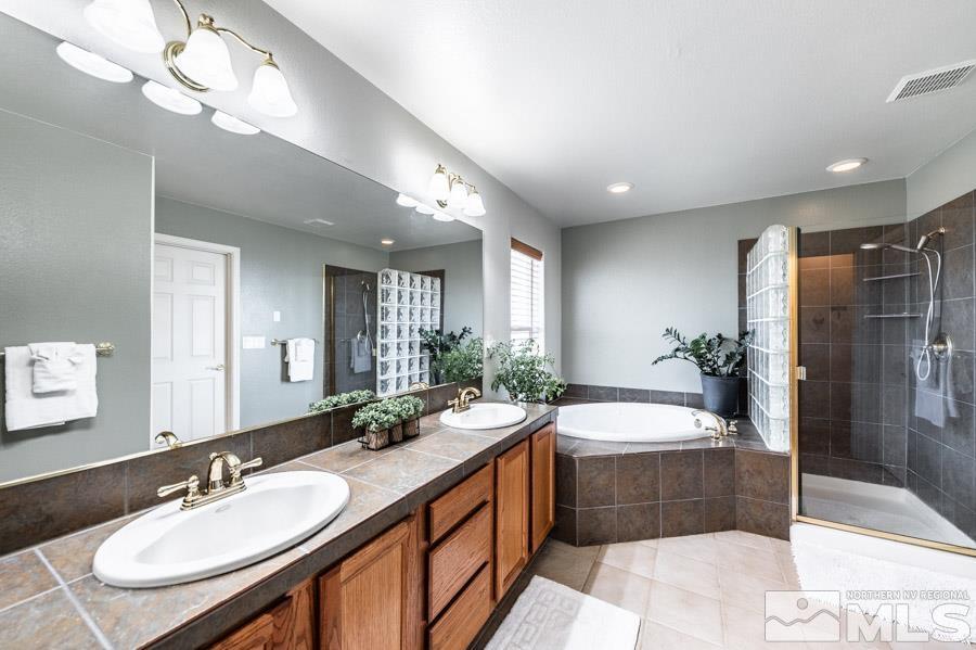 200 Antelope Valley Road Reno, NV 89506 - Photo 16 of 28 a spacious bathroom with a double vanity sink a large mirror and a bathtub