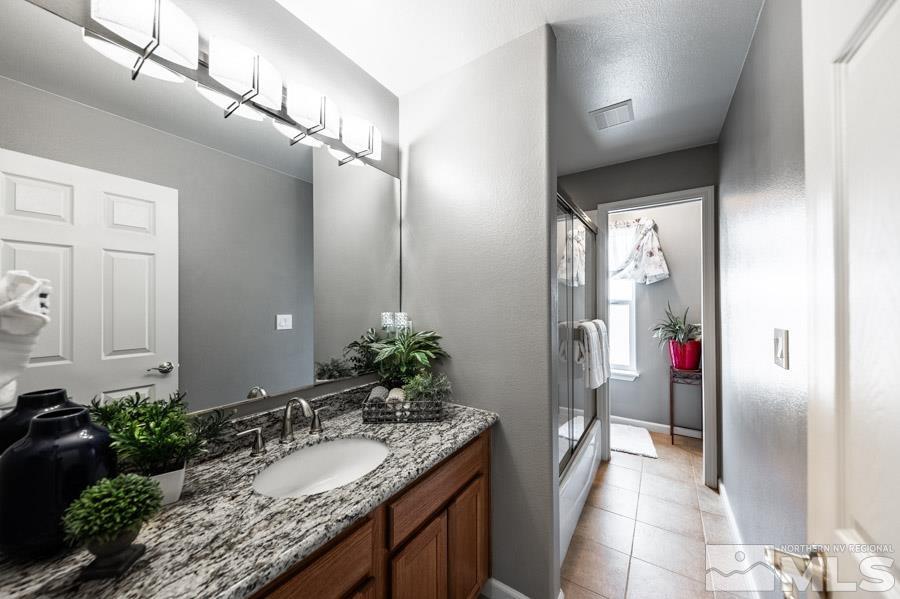 200 Antelope Valley Road Reno, NV 89506 - Photo 18 of 28 a bathroom with a granite countertop sink a mirror and a shower