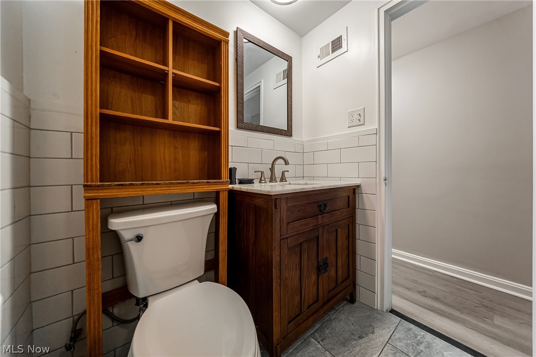 13800 Fairhill Road, Unit 306 Cleveland, OH 44120 - Photo 35 of 48 Full bath with vanity, tile walls, light tile patterned floors, and a wainscoted wall