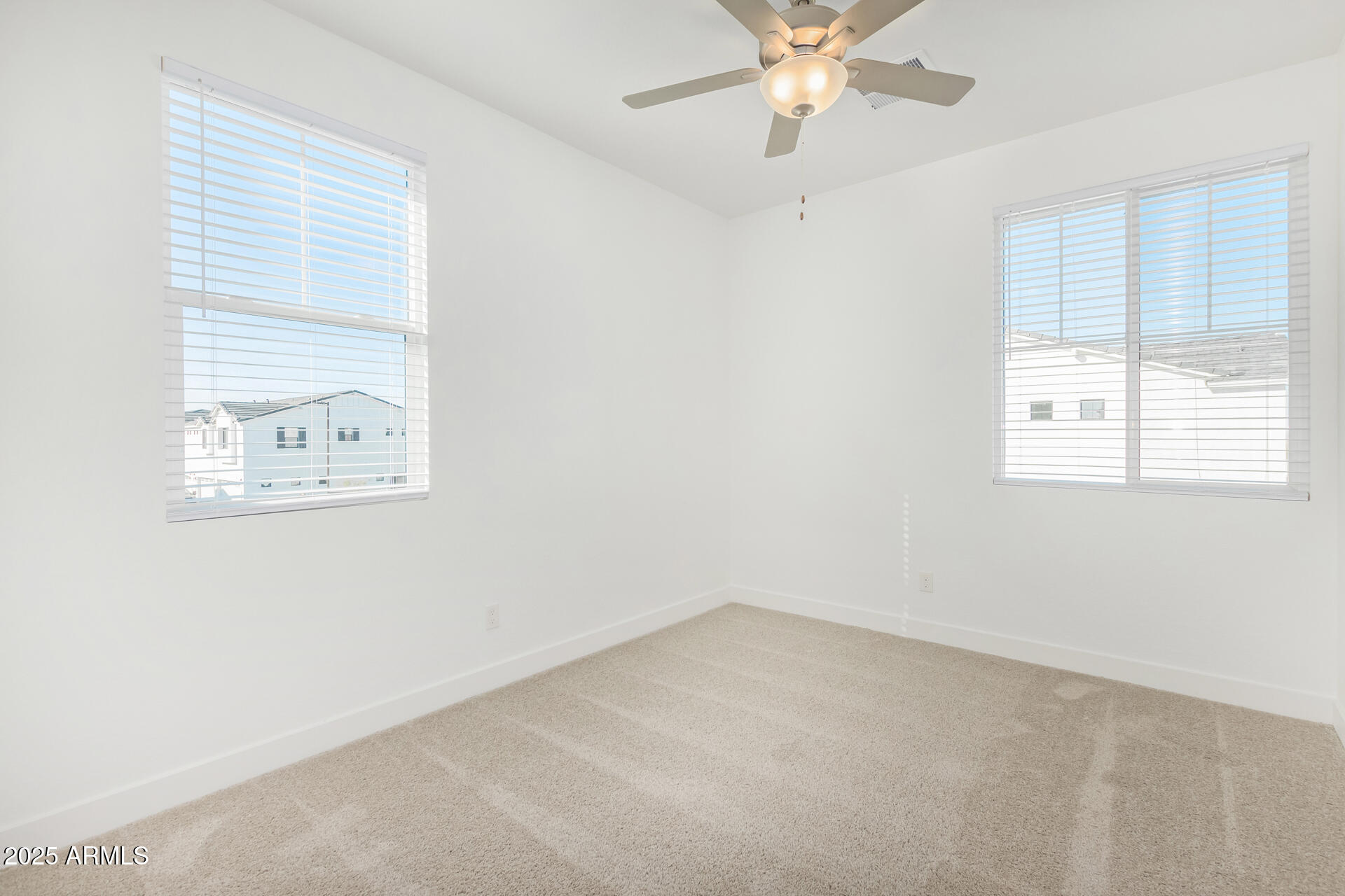 3230 East Thomas Road, Unit 112 Mesa, AZ 85213 - Photo 20 of 32 an empty room with a window and a fan