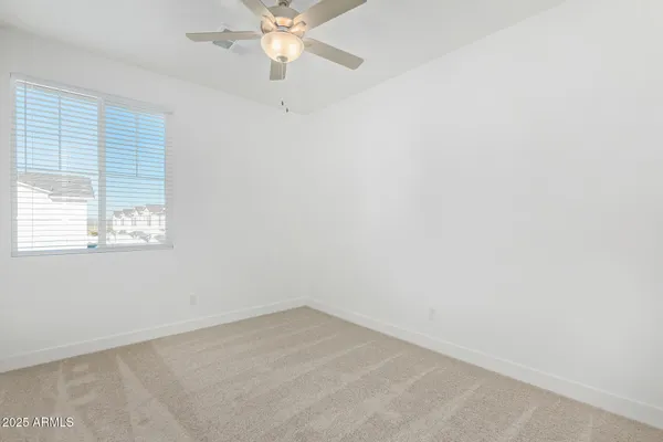 an empty room with a ceiling fan and closet