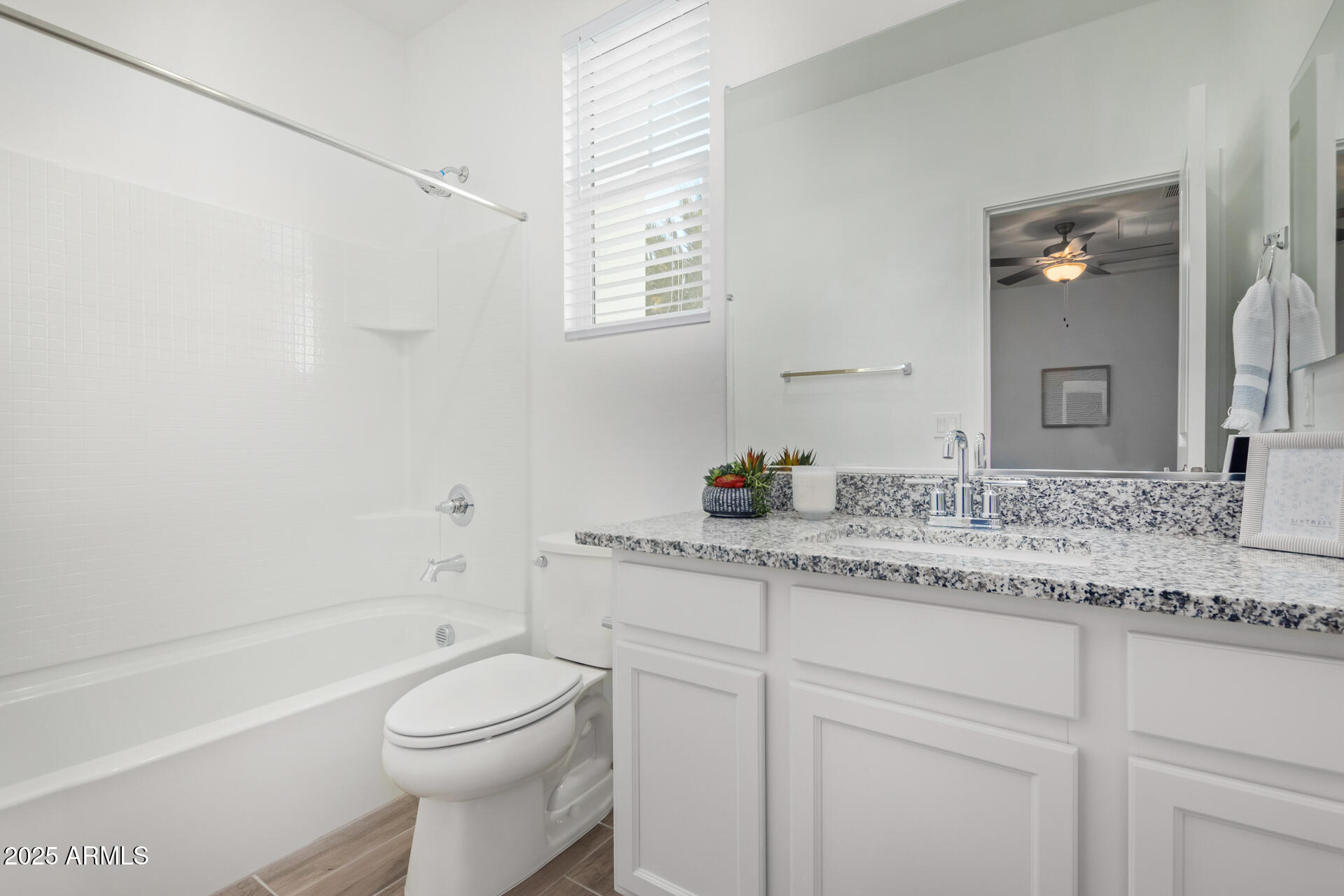 3230 East Thomas Road, Unit 112 Mesa, AZ 85213 - Photo 24 of 32 a bathroom with a granite countertop toilet sink and mirror