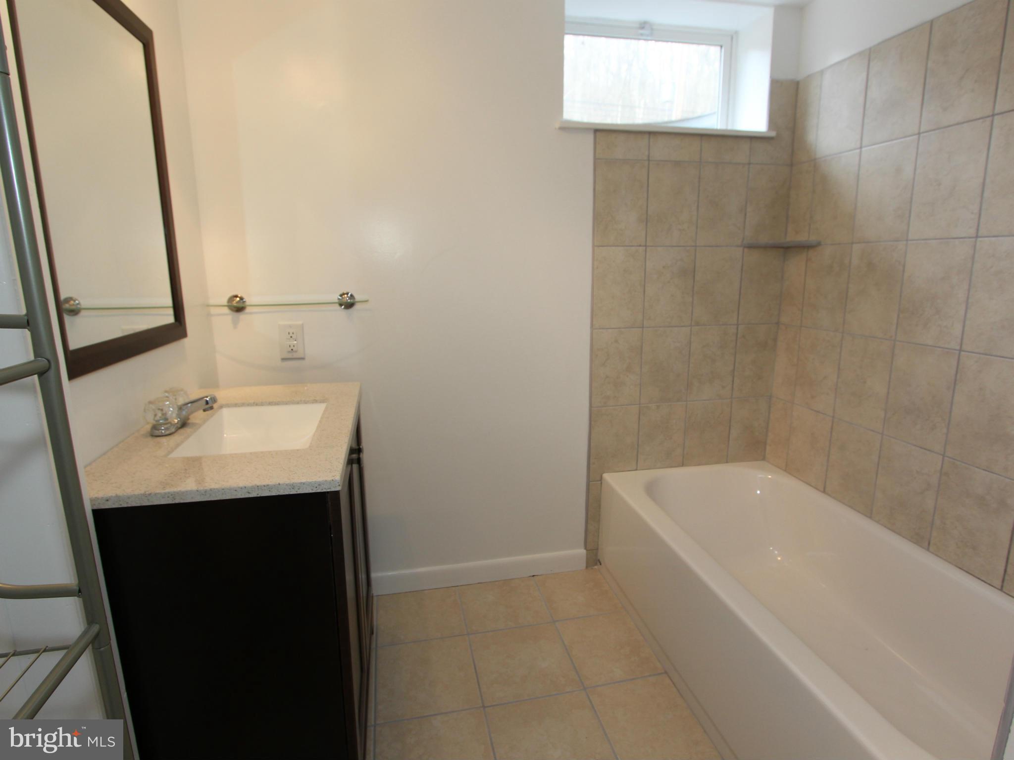 5047 Shookstown Road Frederick, MD 21702 - Photo 15 of 30 a bathroom with a sink a bathtub and a window