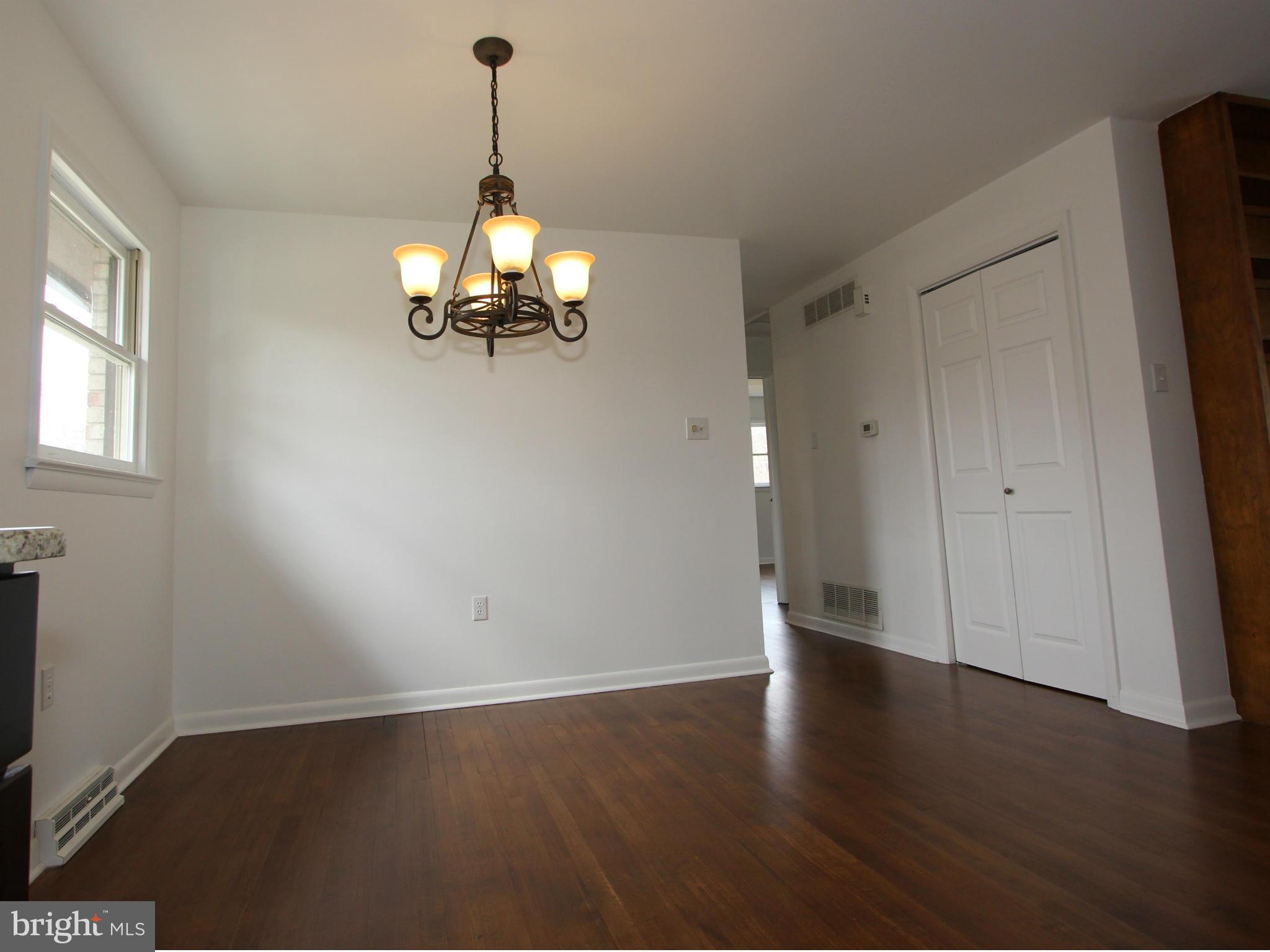 5047 Shookstown Road Frederick, MD 21702 - Photo 6 of 30 an empty room with wooden floor cabinet and windows