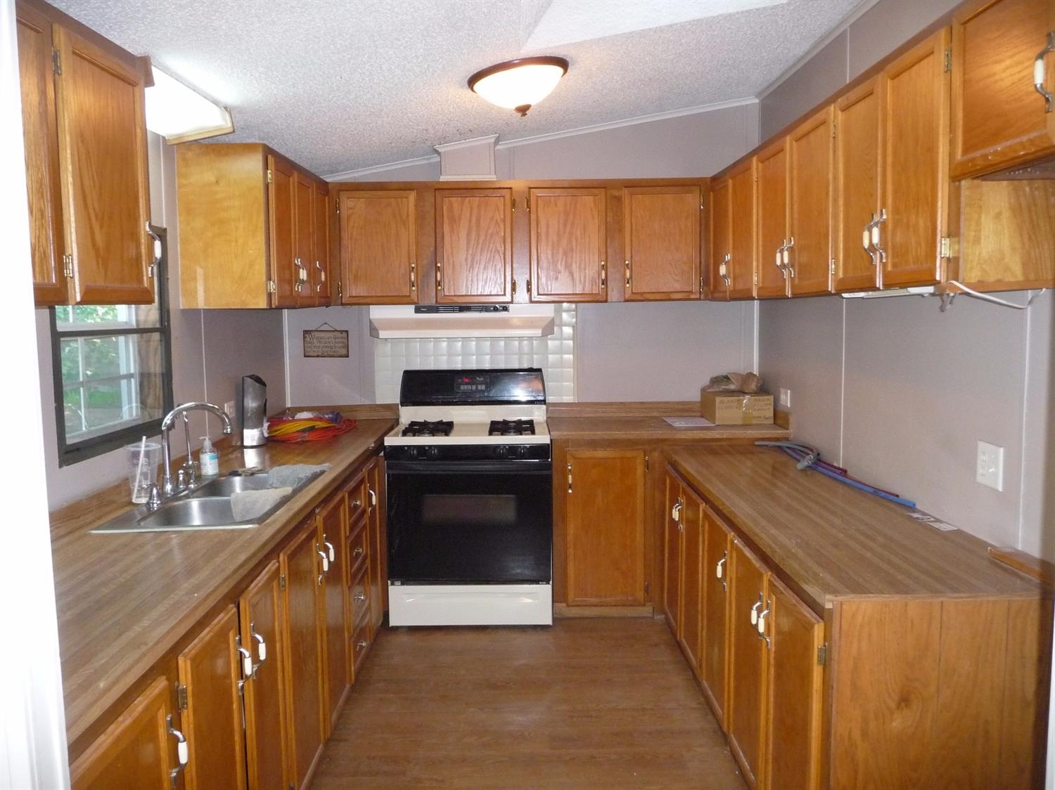 11889 Old Colony Road Demotte, IN 46310 - Photo 2 of 10 a kitchen with a stove top oven sink and cabinets