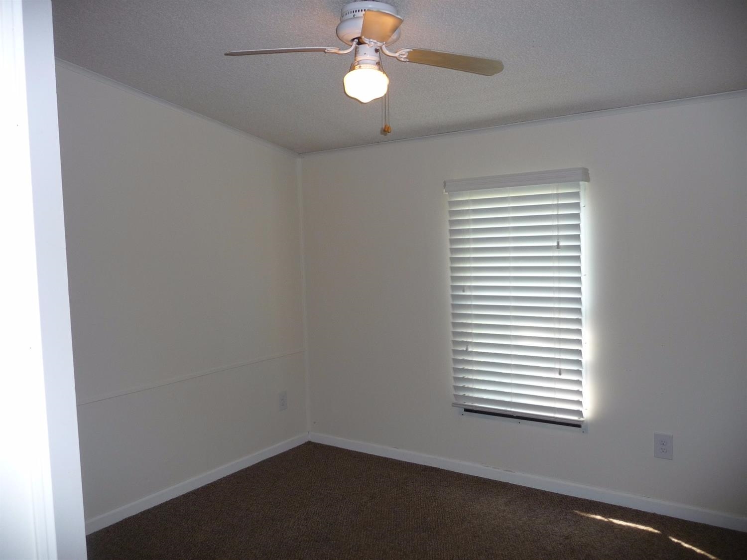 11889 Old Colony Road Demotte, IN 46310 - Photo 7 of 10 an empty room with a window and a fan