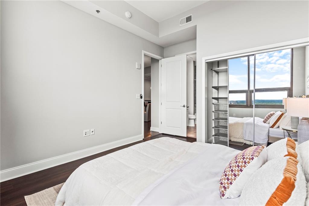 270 17th Street Northwest, Unit 4306 Atlanta, GA 30363 - Photo 24 of 54 a bedroom with a bed and a large window
