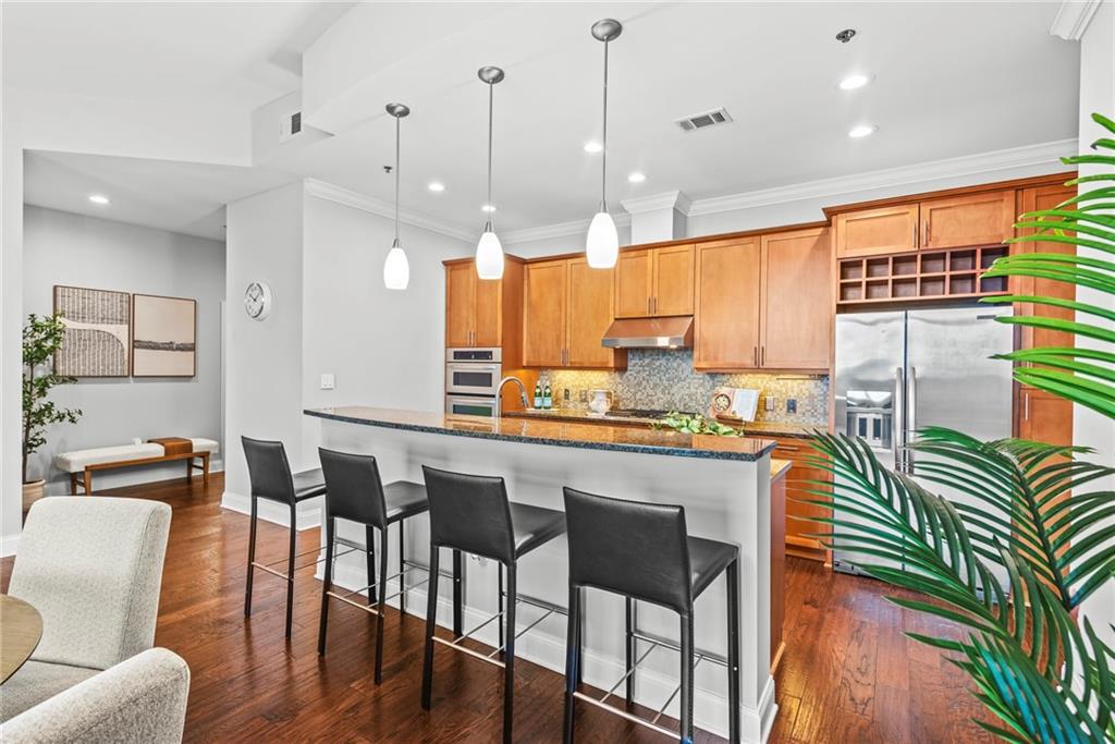 270 17th Street Northwest, Unit 4306 Atlanta, GA 30363 - Photo 10 of 54 a kitchen with stainless steel appliances granite countertop a stove a sink a refrigerator a dining table and chairs with wooden floor