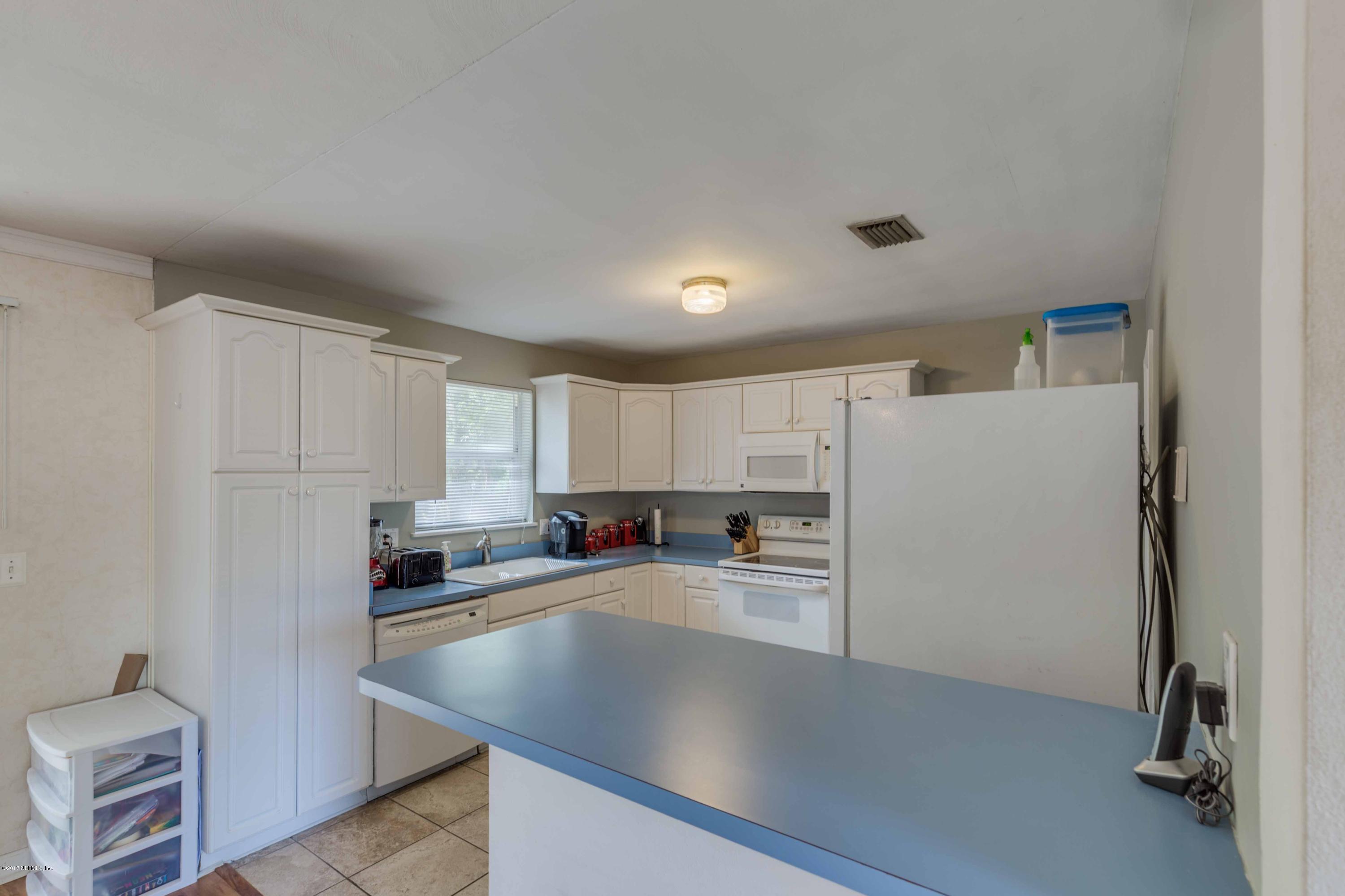 4020 Rogero Road Jacksonville, FL 32277 - Photo 11 of 23 a kitchen with refrigerator and cabinets