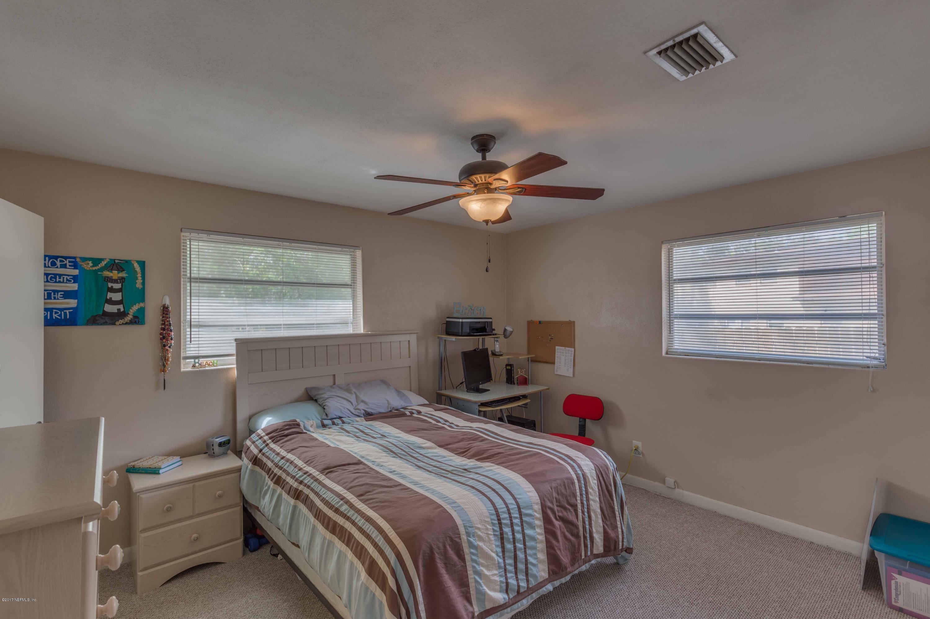 4020 Rogero Road Jacksonville, FL 32277 - Photo 18 of 23 a bedroom with a bed and a chandelier