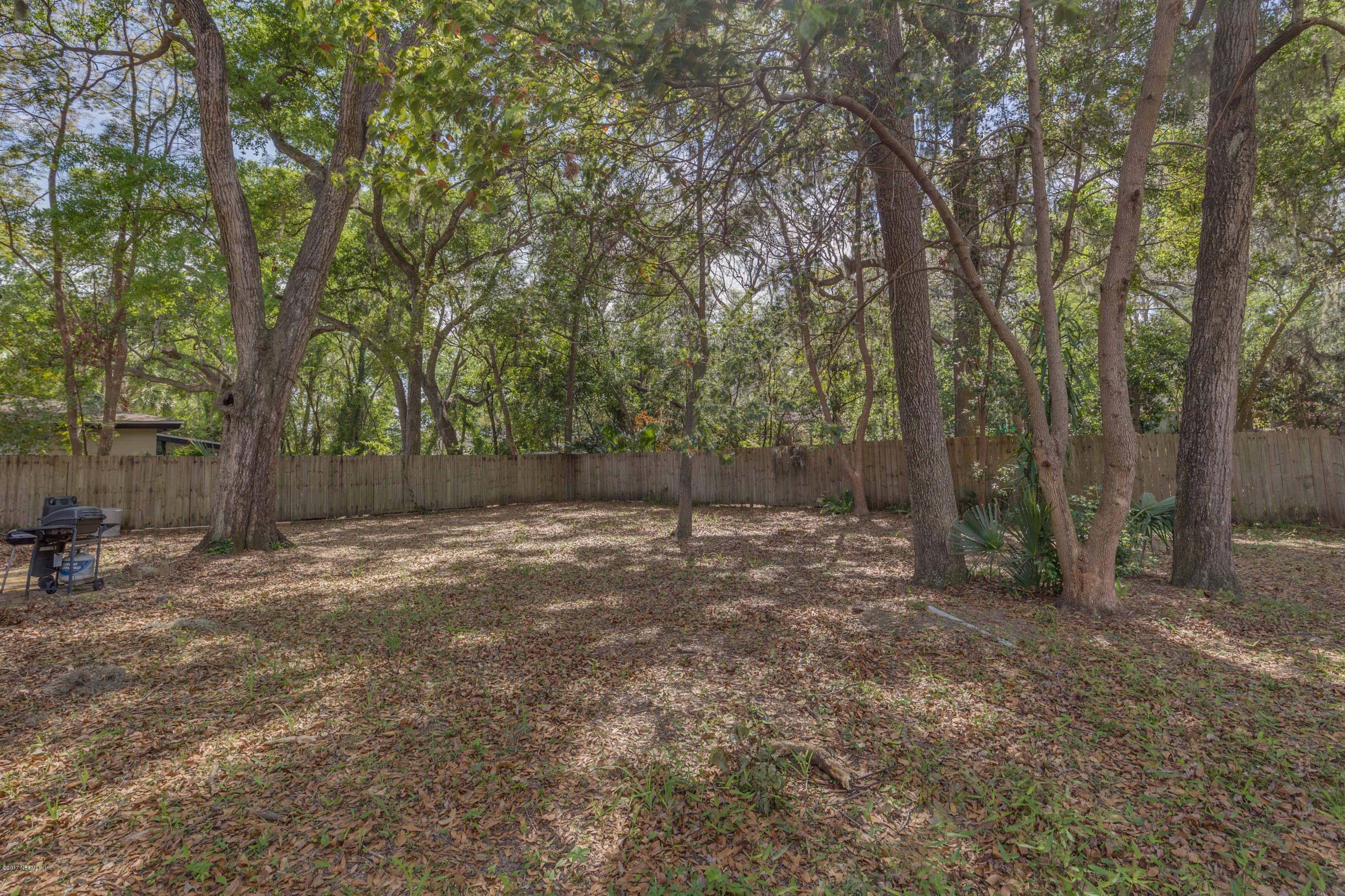 4020 Rogero Road Jacksonville, FL 32277 - Photo 20 of 23 a view of a backyard with large trees