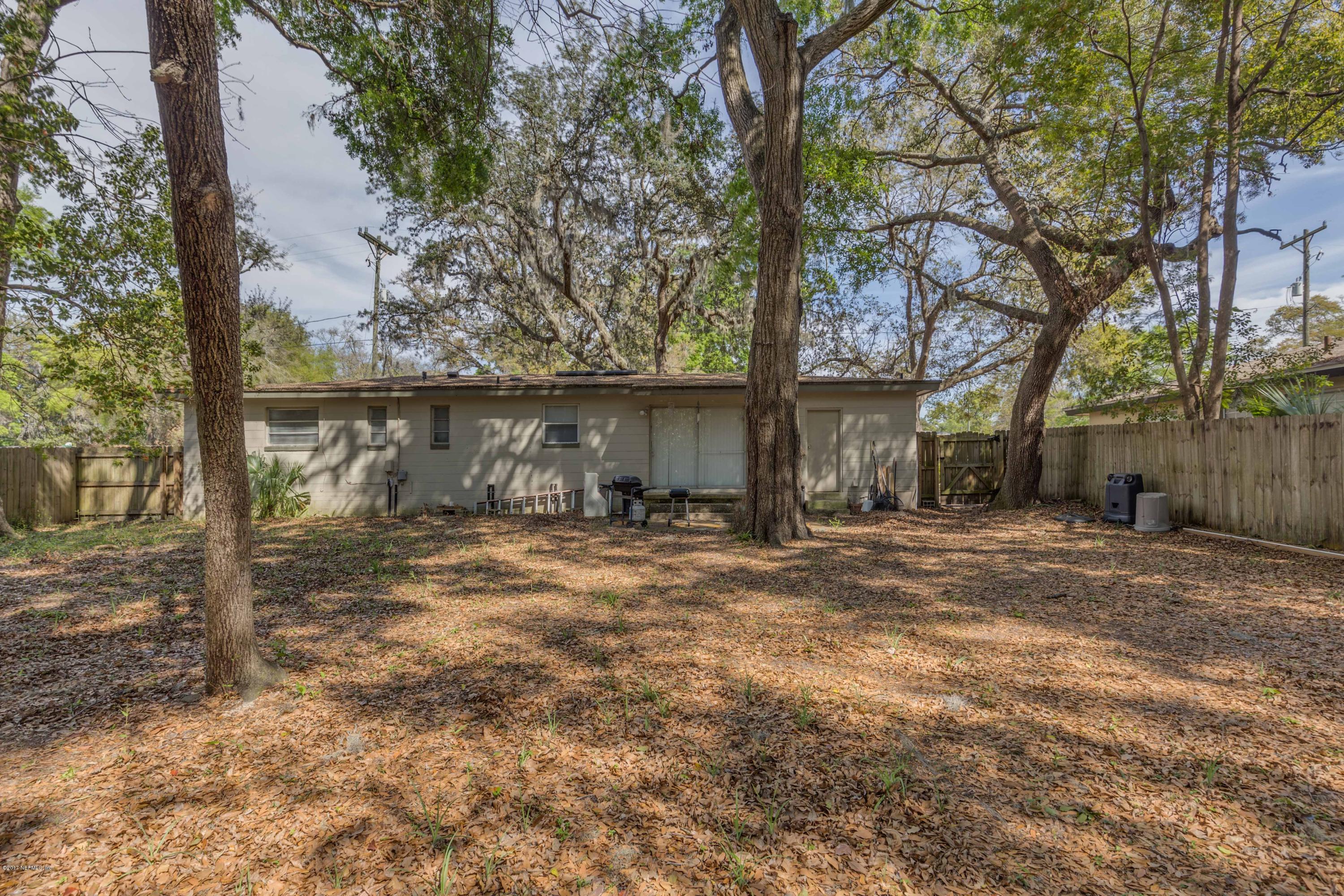 4020 Rogero Road Jacksonville, FL 32277 - Photo 22 of 23 a view of a yard in front of a house with large tree